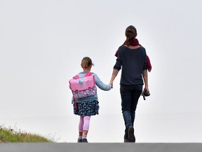 A girls walks to her primary school with her mother on the first day of the new school year in Vertou, western France.