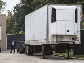 A security guard keeps an eye on a trailer where bodies were reportedly stored in a rented trailer as the medical examiner copes with space shortage in Edmonton on Sept. 11, 2019.