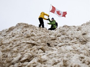 Brothers Tim Utting, 9, and Ben Utting, 12, hoist the Canadian flag after summiting a huge snow pile in Edmonton's Hawrelak Park Sunday Feb. 9, 2020. The two had been taking part in the Birkie Sunday event. Over 100 cross-country skiers took part in the family-oriented event.