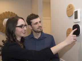 Tracy Topham and Matthew Buxton test out a smart thermostat at a Jayman Built show home.