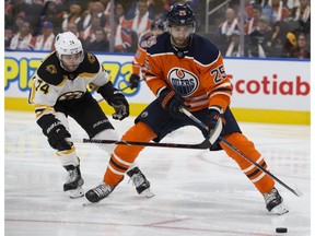 The Edmonton Oilers' Darnell Nurse (25) battles the Boston Bruins' Jake DeBrusk (74) at Rogers Place on Oct. 18, 2018.