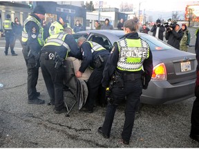 An elderly woman is arrested on Feb. 10, 2020, after police were compelled to act on a BC Supreme Court order, in response to a request from the Vancouver Fraser Port Authority, to restore access to the Vancouver ports in Vancouver. A number of protestors refused to abide by the court order. So far, 33 arrests have been made. Protesters received several requests from police to clear the intersection and then warnings prior to being detained.