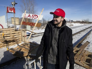 A counter protester wearing a Make Canada Great Again tears down a blockade along the CN rail line near 213 Street and 110 Avenue, in Edmonton Wednesday Feb. 19, 2020. A separate group of protesters had set up the blockade in solidarity with Wet'suwet'en Hereditary Chiefs.