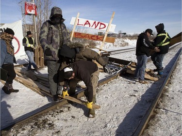A protester tries to block counter protesters from tearing down a blockade at the CN rail line near 213 Street and 110 Avenue, in Edmonton Wednesday Feb. 19, 2020. Protester put up the blockade in solidarity with Wet'suwet'en Hereditary Chiefs.