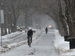 Cyclists use the bike lane along 83 Ave. as a brief snow fall moves through Edmonton, February 4, 2020.