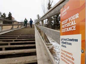 Runners exercise on the Royal Glenora stairs in Edmonton, on Monday, March 30, 2020. Physically distancing by a minimum of two metres or six feet is required during the COVID-19 pandemic to prevent the spread of the novel coronavirus.