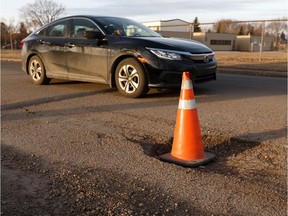 A traffic cone warns drivers of a large pothole near Concordia University at 73 Street and 111 Avenue in Edmonton, on Tuesday, April 2, 2019.