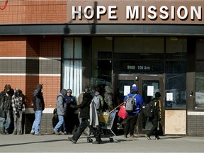 People lined up outside the Hope Mission in Edmonton on March 19, 2020 during the global COVID-19 pandemic.