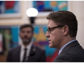 Mayor Don Iveson, left, listens as deputy city manager Adam Laughlin talks about how Edmonton city council has declared a state of local emergency, granting new powers to administration to restrict movement within the city and fix prices on March 20, 2020, in Edmonton.