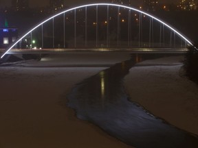 The Walterdale Bridge is seen as snow falls over the North Saskatchewan Bridge at night in Edmonton on Tuesday, March 24, 2020.