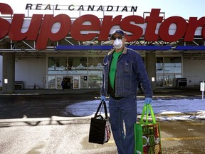 Edmonton resident Lloyd Kitchen leaves the Real Canadian Superstore in south Edmonton with groceries.