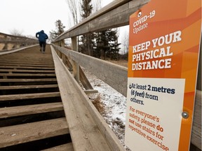 Runners exercise while maintaining social distance from others on the Royal Glenora stairs in Edmonton, on Monday, March 30, 2020.