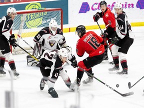 Justin Sourdif tries to take a puck out of danger in front of goaltender Drew Sim in the Vancouver Giants' game on Saturday on the road against the Prince George Cougars. It was the first-ever WHL start for Drew Sim.