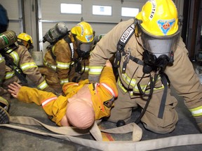 BLCK DIAMOND, Volunteer firefighters haul a dummy victim out during a training drill at the Black Diamond fire hall. File photo.