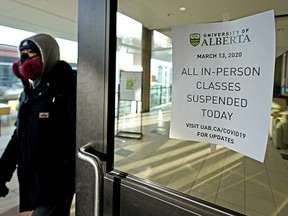 A masked student leaves the Students' Union Building at the University of Alberta in Edmonton on Friday, March 13, 2020. All classes at the university have been suspended until further notice due to the global COVID-19 pandemic.
