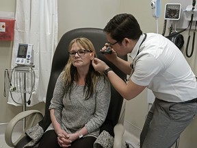 Dr. Joel Giddey examines patient Tammy Cyr at the Shale Medical Clinic in Drayton Valley, Alberta on March 3, 2020. (PHOTO BY LARRY WONG/POSTMEDIA)