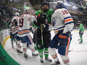 Dallas Stars left wing Jamie Benn (14) is tied up by Edmonton Oilers right wing Alex Chiasson (39) and left wing James Neal (18) at American Airlines Center.