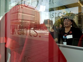 Josie Nepinak (Awo Taan Healing Lodge Society), executive director of the only Indigenous urban women's shelter in Alberta, looks at a red dress on display at the Federal Building in Edmonton on March 5, 2020, where the Alberta government announced the next steps they will take on the issue of missing and murdered Indigenous women and girls. (PHOTO BY LARRY WONG/POSTMEDIA)