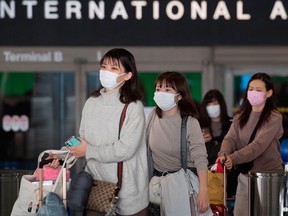 Passengers wear face masks to protect against the spread of the COVID-19, coronavirus, as they arrive at LAX airport in Los Angeles on Feb. 29, 2020.