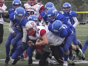 The Spruce Grove Cougars gang tackle a West Edmonton Raiders ball carrier in Capital District Minor Football Association play in September 2019. The association has announced the cancellation of the 2020 Spring season due to COVID-19 measures.