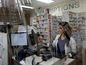 A pharmacist works at Terwillegar Pharmacy in southwest Edmonton. Alberta’s chief medical officer is warning of prescription-dispensing abuse for drugs that are possibly, but not conclusively, linked to fighting COVID-19.