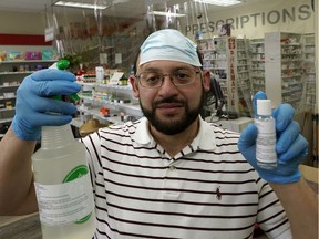 Mohamed Elfishawi holds bottles of hand sanitizer that he makes and sells at his pharmacy during the COVID-19 pandemic. He is the pharmacist/owner of Terwillegar Pharmacy in southwest Edmonton.