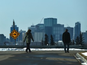 Two people keeping their distance while out for a walk along Ada Blvd. in Edmonton, April 6, 2020.