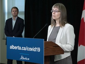Health Minister Tyler Shandro, left, listens as Alberta's chief medical officer of health Dr Deena Hinshaw speaks during a news conference in the Federal Building on Monday, April 20, 2020.