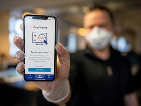 A man holds a smartphone showing a tracking and tracing app launched by the National Institute of Public Health to try to halt a return of the new coronavirus, on April 17, 2020 in Oslo. - (Photo by Heiko Junge / NTB Scanpix / AFP) / Norway OUT (Photo by HEIKO JUNGE/NTB Scanpix/AFP via Getty Images)
