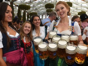 (FILES) This file photo taken on September 21, 2019 shows a waitress serving beer mugs after the opening of the Oktoberfest beer festival in a festival tent at the Theresienwiese fair grounds in Munich, southern Germany. - Germany's Oktoberfest beer festival will be cancelled in the year 2020 as "risks are too high" from the novel coronavirus, Bavarian state premier Markus Soeder said Tuesday, April 21, 2020. (Photo by Christof STACHE / AFP)