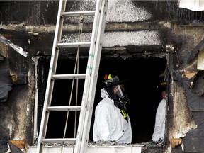 Fire investigators work at the scene of a fire at the Spanish Villa apartment building, 9424 149 St., in Edmonton Monday April 27, 2020. Two residents were taken to hospital.