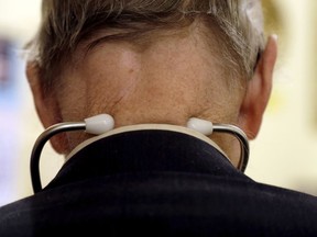 A doctor wears a stethoscope around his neck as he tends to patients.