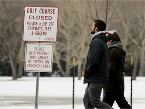 Pedestrians walk through the closed Victoria Golf course, in Edmonton Thursday April 9, 2020.