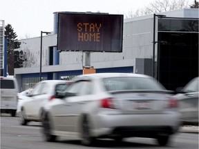Traffic makes its way past a City of Edmonton sign that flashes the message "Prevent COVID-19 Spread, Stay Home" along Calgary Trail near 48 Avenue, in Edmonton Friday April 3, 2020.