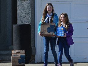 Girl Guide sisters, Paige Bradley, 12, and Jaide Bradley, 9, can't go door-to-door anymore to sell cookies, so now they deliver them to peoples door and the purchaser put cash in the mailbox in Sherwood Park on Wednesday, April 8, 2020.
