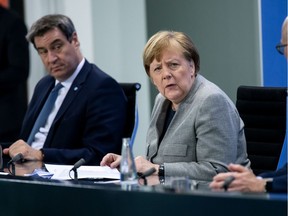 German Chancellor Angela Merkel, Bavarian Prime Minister Markus Soeder and Hamburg mayor Peter Tschentscher hold a news conference after discussing with German state premiers on whether to prolong or phase-out the lockdown to combat COVID-19 at the Chancellery in Berlin, Germany, April 15, 2020, as the spread of the coronavirus disease (COVID-19) continues in Munich.        Bernd von Jutrczenka/Pool via REUTERS ORG XMIT: JOH231