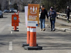 Edmontonians make their way along Saskatchewan Drive where a lane of vehicle traffic has been closed to encourage physical distancing, Friday April 10, 2020.