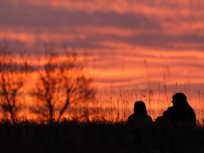 A couple take in a red sunset from Strathcona Science Provincial Park between Edmonton and Sherwood Park, on Wednesday, May 13, 2020. Photo by Ian Kucerak/Postmedia