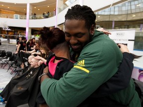 Long time supporter Shauna Buist (left) gets a hug from Edmonton Eskimos offensive linesman Travis Bond during the 17th annual Hair Massacure held in support of the Children's Wish Foundation and Terry Fox PROFYLE charities, at West Edmonton Mall in Edmonton, on Friday, Feb. 22, 2019.