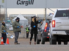 Union members used poles to hand out masks and information to workers entering the Cargill plant near High River while protesting the meat processing plant reopening on Monday, May 4, 2020. The plant had been temporarily shut down after hundreds of workers contracted COVID-19. The union says the plant is still not a safe for workers.