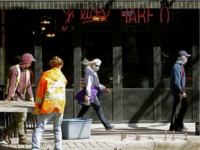 Workers install sidewalk patio barriers outside Julio's Barrio Mexican Restaurant on Whyte Avenue in Edmonton on Tuesday May 12, 2020. The restaurant and bar will open on Thursday May 14, 2020 when the Alberta government's economic lockdown during the COVID-19 pandemic is lifted.
