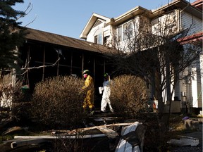 Edmonton Fire Rescue Services investigators work after a fire damaged a home at 5215 201 Street in Edmonton, on Thursday, May 14, 2020.