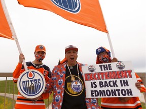 Edmonton Oilers superfan Blair Gladue, centre, his brother Clayton Cardinal, right, and his nephew Brody Gladue cheered from the bridge at St. Albert Trail and Anthony Henday Drive after hearing about the resumption of the NHL playoffs on May 26, 2020.