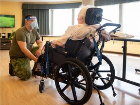 In this image obtained from Canadian Armed Forces Combat Camera, a Canadian soldier aids a senior citizen on May 10, 2020, at the Vigi Queen Elizabeth Residential and Long-Term Care Centre in Montreal, Quebec, as part of Operation LASER. Canada announced on May 12. 2020, a onetime payment of up to Can$500 (US$360) for seniors -- who as a group have suffered the most COVID-19 sickness and fatalities -- to help defray added pandemic costs of living. An estimated seven million elderly Canadians qualify for the aid. "The last few weeks have been particularly tough for our seniors and their families," Prime Minister Justin Trudeau told a daily briefing.