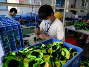 Workers wearing face masks assemble toy cars at the Mendiss toy factory in Shantou, southern China's Guangdong province on May 20, 2020.