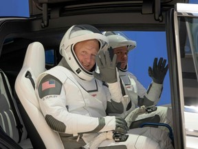 NASA astronauts Douglas Hurley, left, and Robert Behnken, wearing SpaceX spacesuits, wave as they depart the Neil A. Armstrong Operations and Checkout Building for Launch Complex 39A on Saturday, May 23, 2020 during a dress rehearsal prior to the upcoming Demo-2 mission launch, at NASA's Kennedy Space Center in Florida.