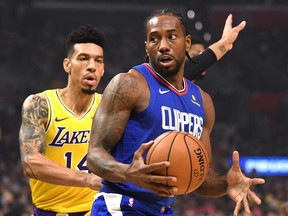 Kawhi Leonard of the LA Clippers spins for a shot in front of Danny Green of the Los Angeles Lakers during a 112-102 Clipper win in the LA Clippers season home opener at Staples Center on Oct. 22, 2019, in Los Angeles.