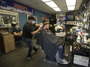 Darren Ewanyk gets a haircut from Nick Moustafa at Mickey's Barber Shop, 8120 Gateway Blvd., as some businesses began to reopen as part of the first phase of Alberta's COVID-19 relaunch, in Edmonton on Thursday, May 14, 2020.