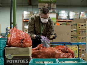 A volunteer packs hampers at Edmonton's Food Bank, 11508 120 St., on April 28, 2020.
