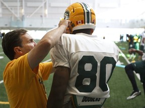 Equipment manager Dwayne Mandrusiak (left) checks wide receiver Mark Dell's (80) helmet during the first day of the Edmonton Eskimos training camp held inside the field house at Commonwealth Recreation Centre in Edmonton on Sunday, June 1, 2014.